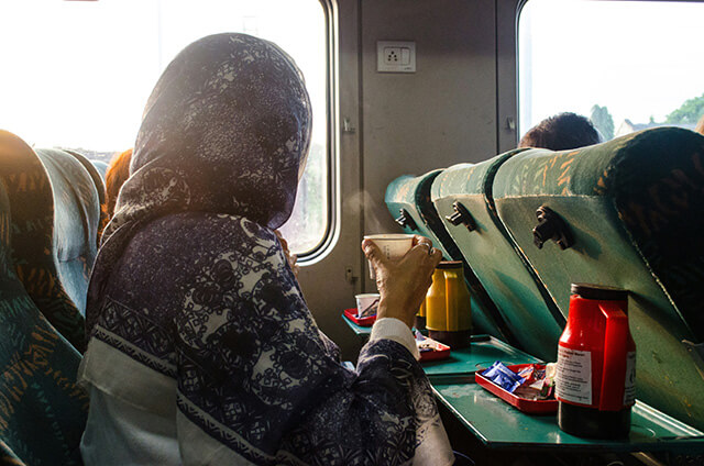 A women eating snacks in a train in India.