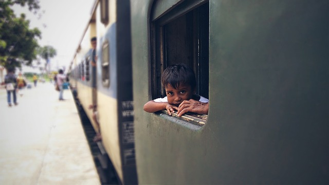 A child looking out of a train in India with curiousity.
