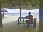 Man working at web development on beach in Cambodia thumbnail.