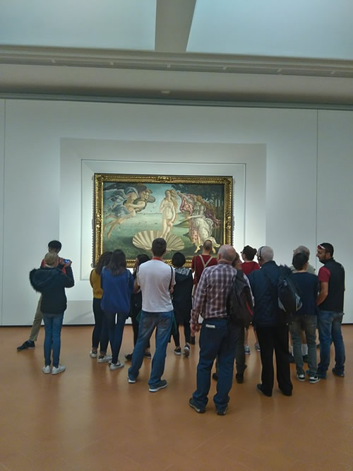Botticelli's Birth of Venus with onlookers at the Uffizi Gallery.