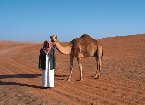 Bedouin with camel in Oman desert.