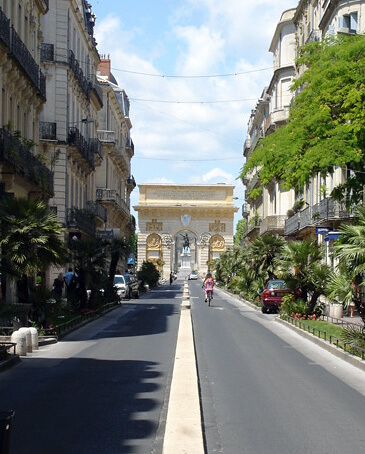 The Arc de Triomphe in Montpellier, France as seen from an approaching main street.