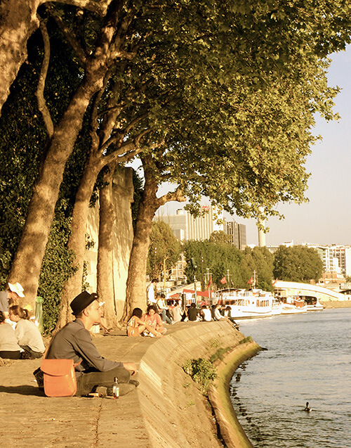Students hanging out in Paris, along the Seine river.