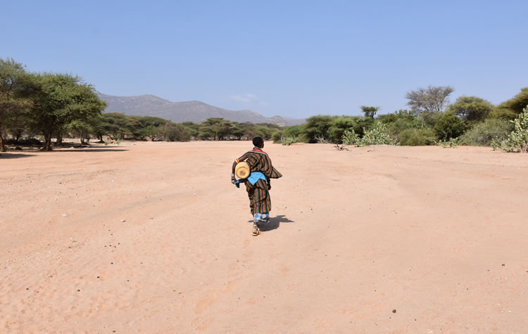 Woman with jerrycan on her way to a water well