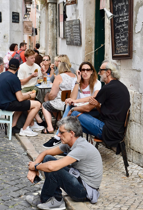 Eating and drinking on the narrow Alfama sidewalks, a historic district of Lisbon