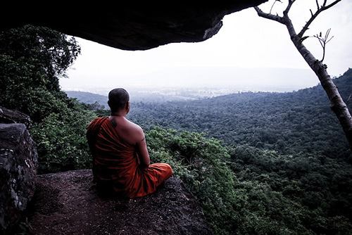 A Bhuddist monk meditating in the forest in Thailand