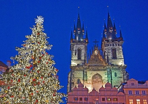 Christmas in Prague, with a big decororated with lights in front of a Cathedral.