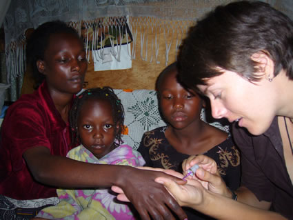 Home-based care in Kenya, volunteer with family putting nail polish on mother.