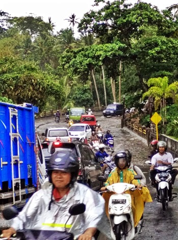 Driving through traffic Bali during rainy season.