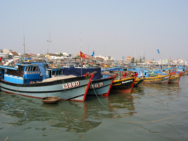 Wooden fishing boats in Vietnamese village harbor.