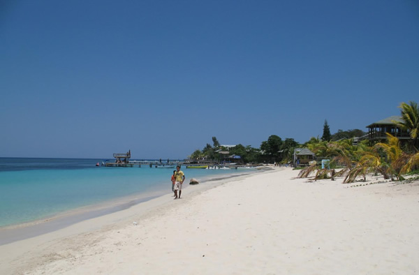 Travel writers overseas walking on a beach in Honduras