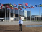 Study abroad to find work with student in front of flags.