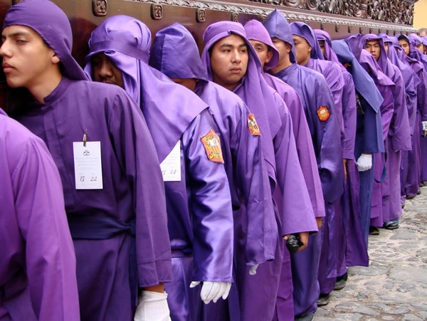 Antigua, Guatemala men in purple carrying a religious float.