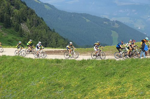 Cycling on a road through hills of the Alps as a group.