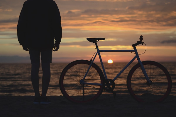 Biking is a great way to explore the world. Biker with bike by the sea.