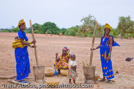Fulani women with creating flower from grain.