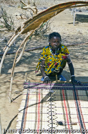 Fulani woman weaves a grass mat.