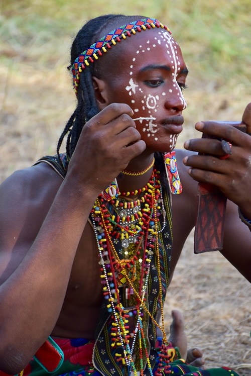 Man applying make-up, in preparation for the Gerewol Festival performances