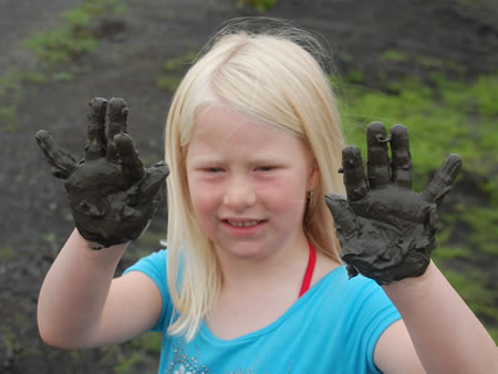 Child showing mud from the flooded grass lands