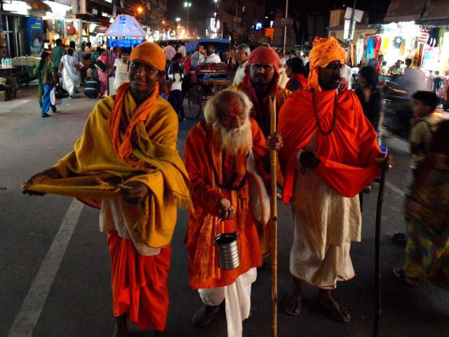 Hindu Indian holy sadhus are walking the street begging for alms at the Kumbh Mela celebration.