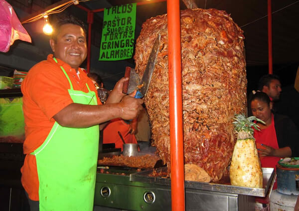 Pork tacos and man cutting pieces