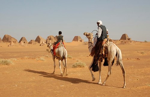 Men on camels at pyramids