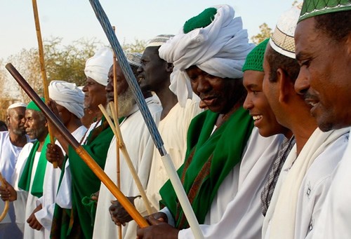 Sufi men gathered with sticks