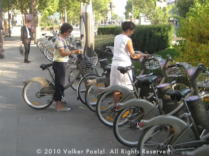 People renting bikes at a Vélib' bicyle station in Paris.