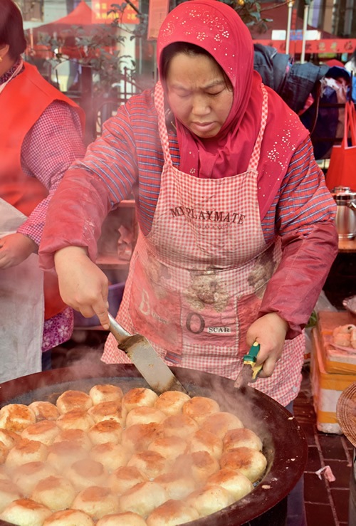 Woman busy cooking at the Friday Muslim Market
