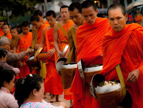 Monks accepting alms of sticky rice during a ceremony