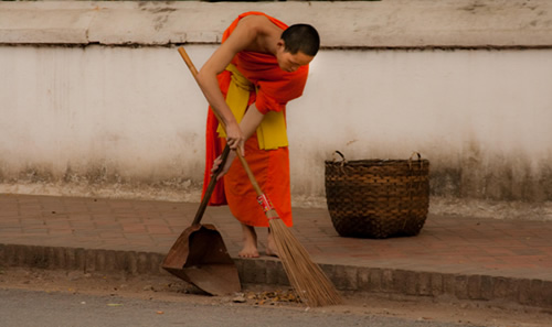 Monk sweeping the street