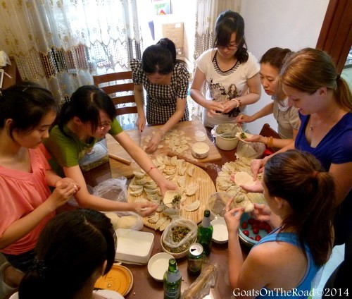A group of the teaching staff teaching Dariece how to make Chinese dumplings.