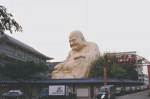 Huge Buddha in Taiwan towering over streets in a neighborhood.