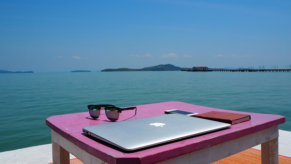 Thailand digital nomad freelancing with laptop overlooking ocean