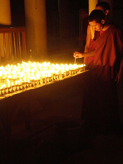 Lighting butter lamps at the Dalai Lama's temple