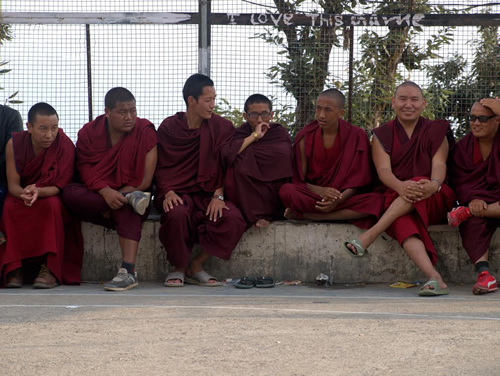 Tibetan monks watching basketball game.