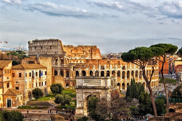 A view of the Roman Colosseum from the Forum amid the pines in Italy.