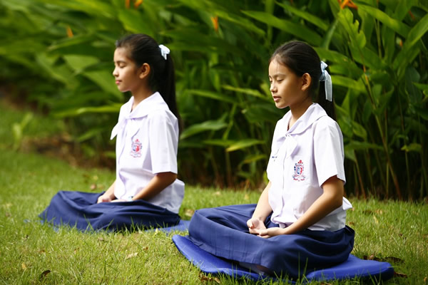 Girls meditating in Thailand.