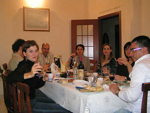 The author is dining and speaking Italian in Italy with her host family.