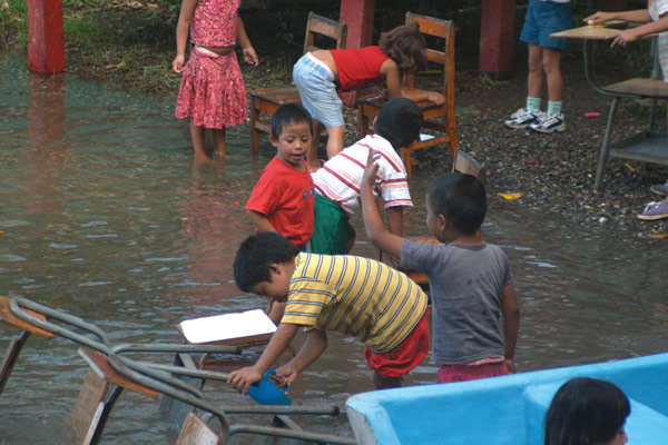Children washing desks in the river