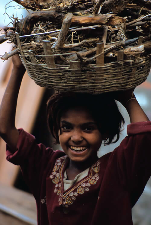 A young girl carrying a basket of wood in Nepal.