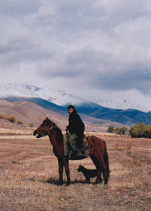 Kyrgyzstan man on horse with dog
