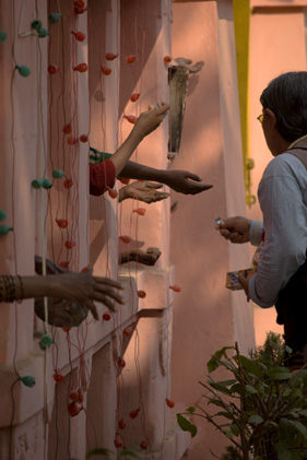 Hands of people through a gate begging for alms in Bodh Gaya, India.