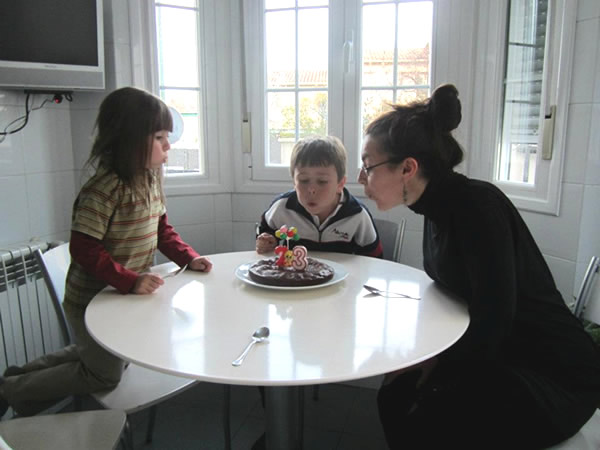 Blowing out birthday candles in Madrid home with children